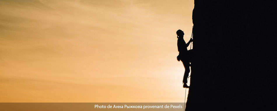 homme en train s'escalader au coucher de soleil